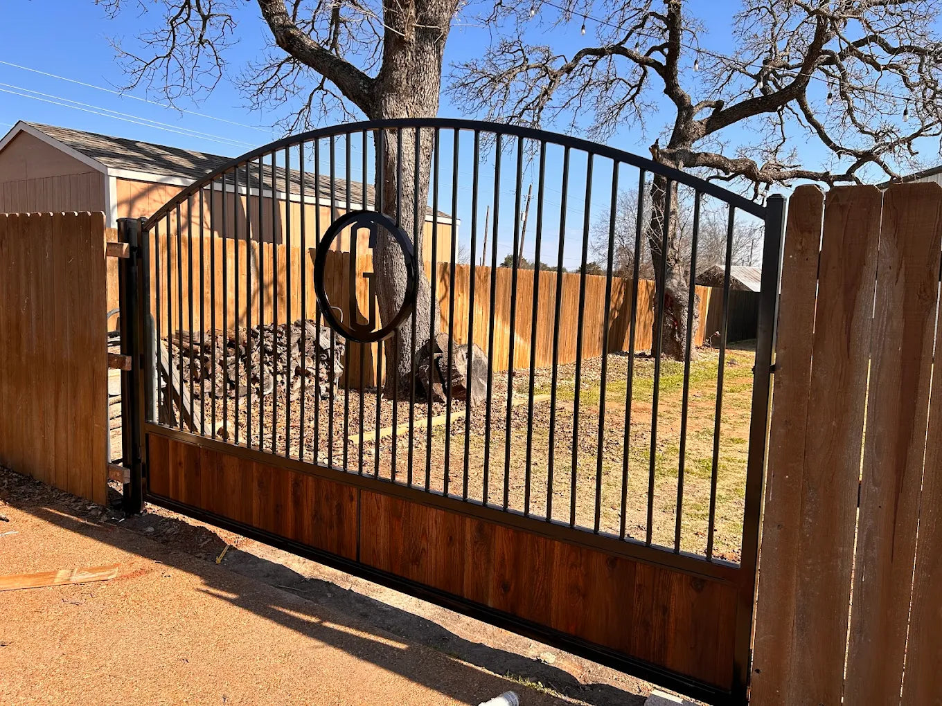 Arch top driveway gate showing curved rail and square picket infill detail — heavy-gauge steel | GateBound
